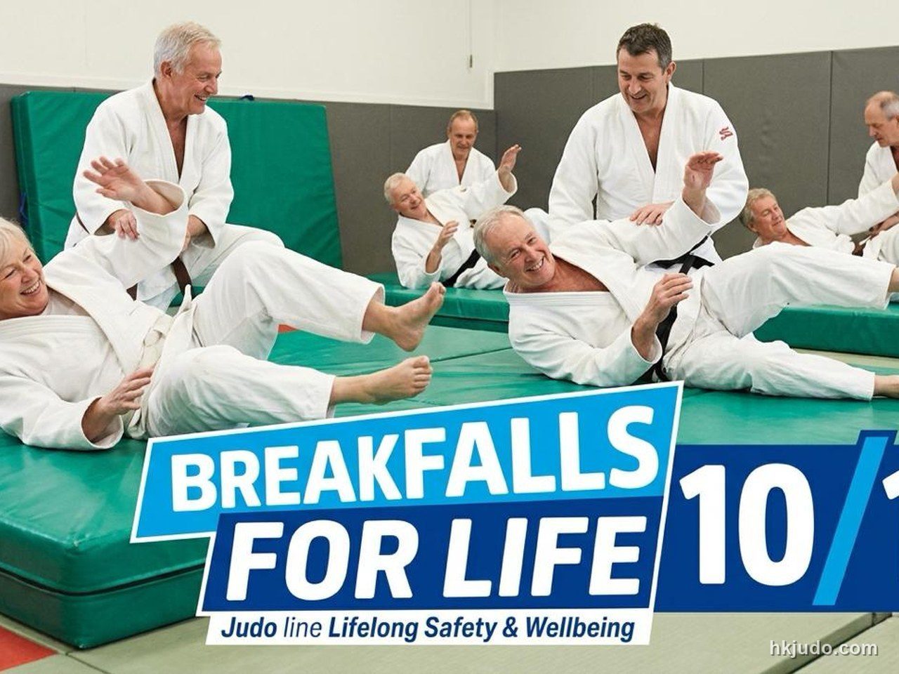多名成年人在道場的綠色軟墊上練習柔道受身,背景有「BREAKFALLS FOR LIFE」標示