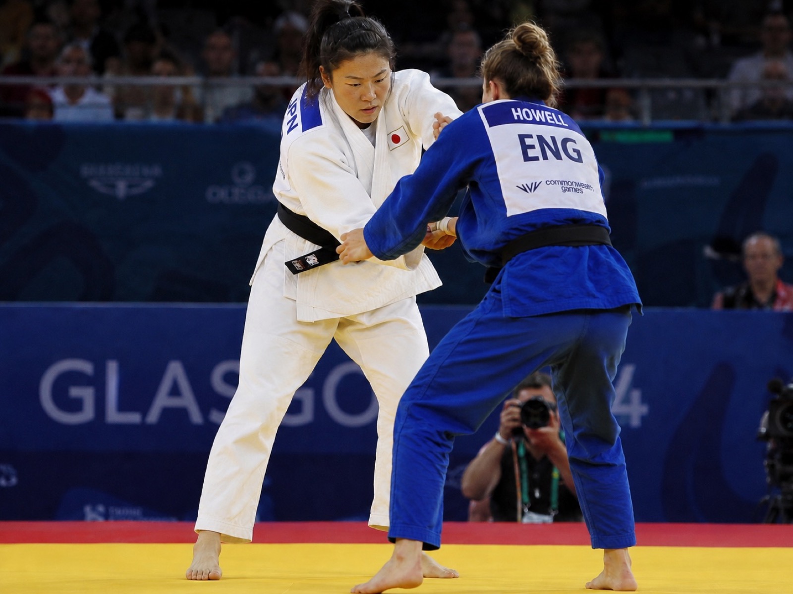 兩名柔道選手在格拉斯哥英聯邦運動會的榻榻米上對賽。